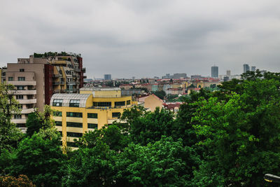 Buildings in city against cloudy sky