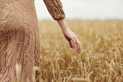 Midsection of woman standing on wheat field