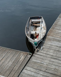 High angle view of man sitting on wooden pier at lake
