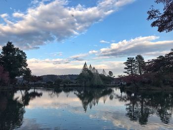 Scenic view of lake by buildings against sky