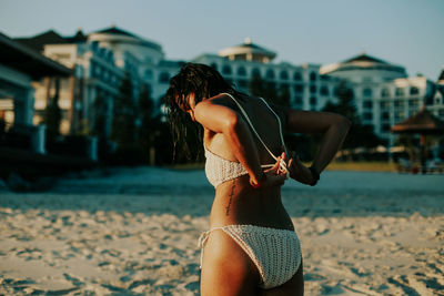 Rear view of woman standing at beach