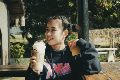 Portrait of smiling boy holding ice cream outdoors