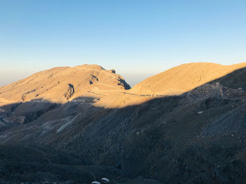 Scenic view of desert against clear blue sky