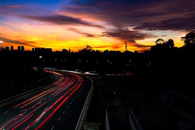 High angle view of light trails on road against sky during sunset