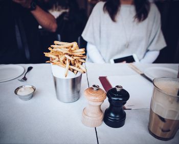 French fires on table against people in restaurant