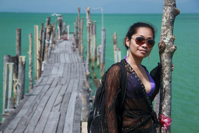 Portrait of young woman standing on pier