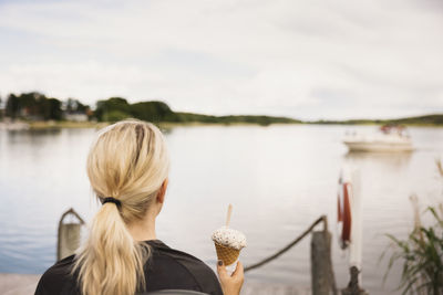 Woman having ice-cream at lake
