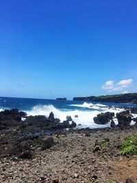 Scenic view of beach against clear blue sky