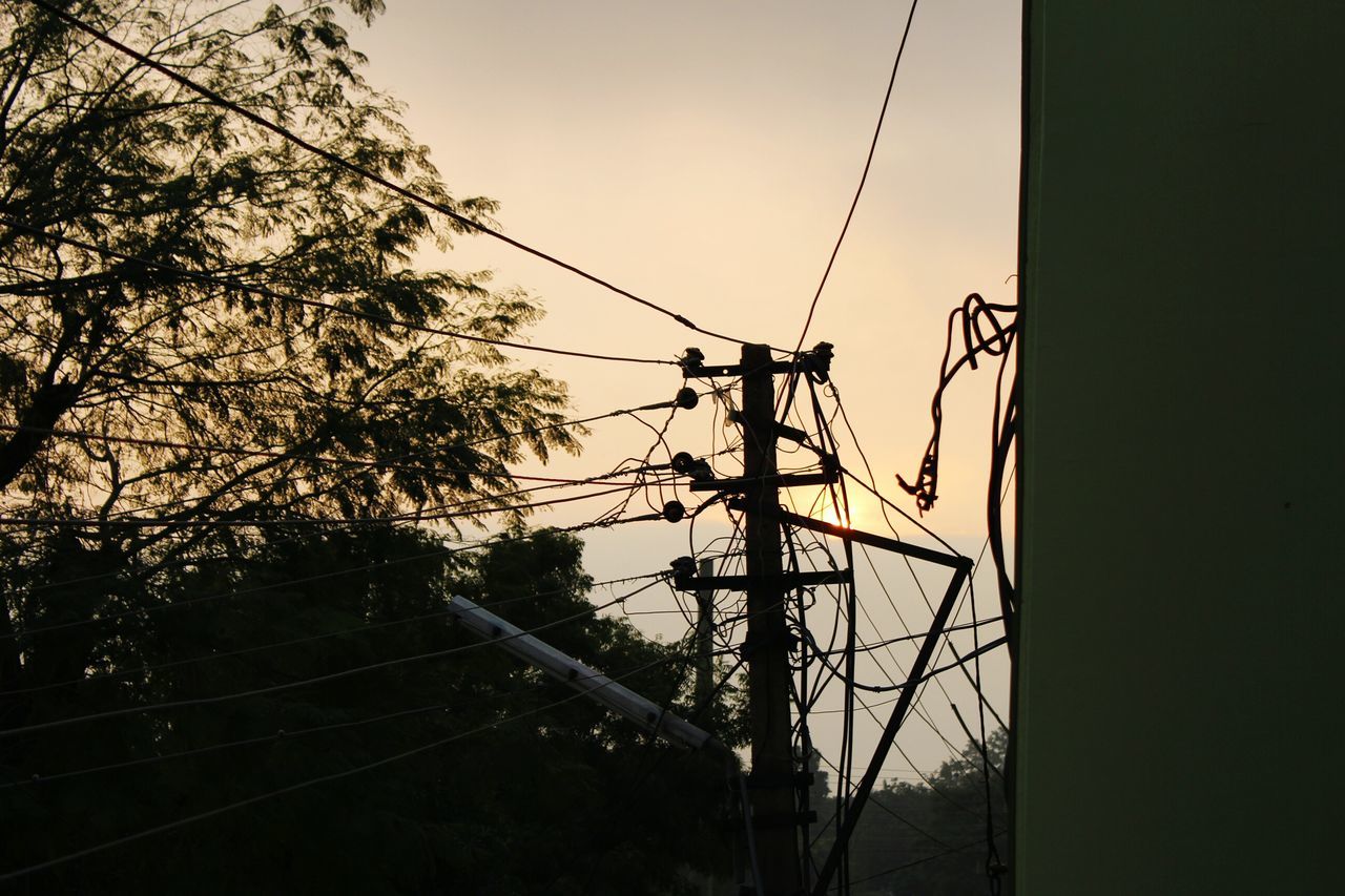 electricity pylon, power line, electricity, power supply, connection, low angle view, tree, fuel and power generation, cable, technology, clear sky, silhouette, sky, complexity, dusk, built structure, outdoors, no people, transportation, power cable