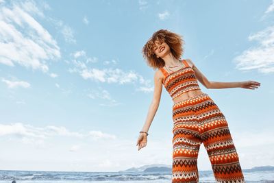 Rear view of woman standing at beach