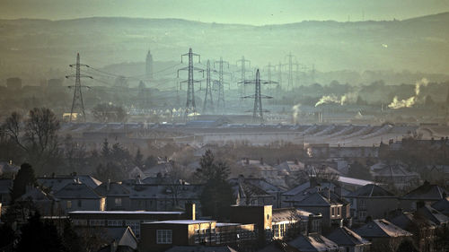 Aerial view of cityscape and mountains against sky