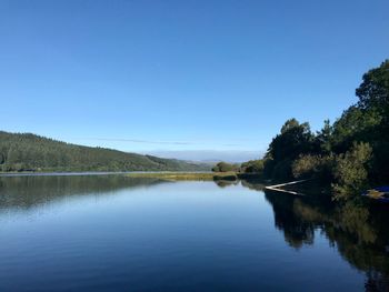 Scenic view of lake against clear blue sky