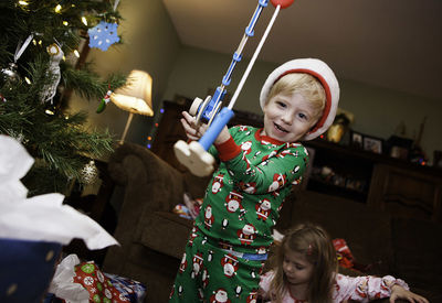 Boy playing with toy fishing rod at home during christmas