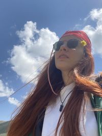 Portrait of woman wearing sunglasses against sky