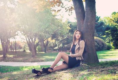 Woman sitting on tree trunk