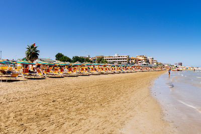 Scenic view of beach against clear blue sky