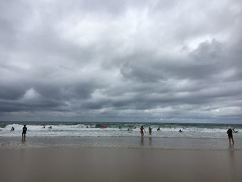 People on beach against sky