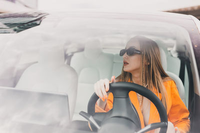 Rear view of woman sitting in car