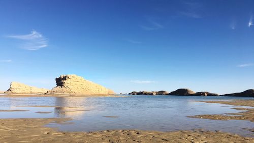 Scenic view of beach against blue sky