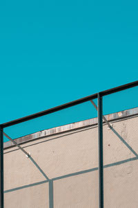 Low angle view of railing against clear blue sky