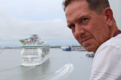 Close-up portrait of man against sea 