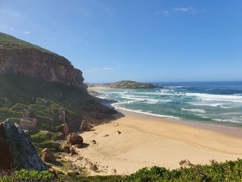 Scenic view of beach against blue sky