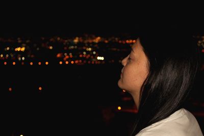 Close-up of woman against illuminated sky at night