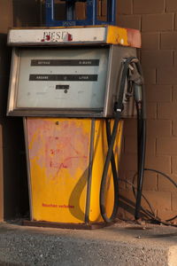 Abandoned yellow fuel pump at gas station