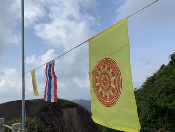 Low angle view of flags hanging against sky