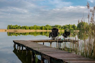 Rear view of man on jetty against lake