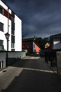 Footpath amidst buildings in city against sky