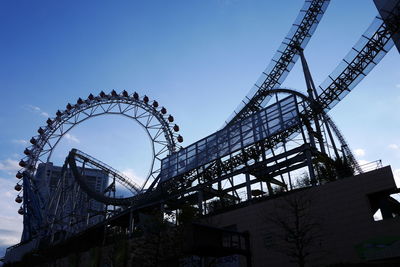 Low angle view of ferris wheel against blue sky