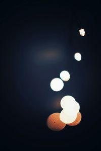 Low angle view of illuminated lights at night