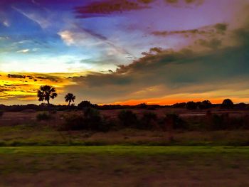 Scenic view of field against sky at sunset