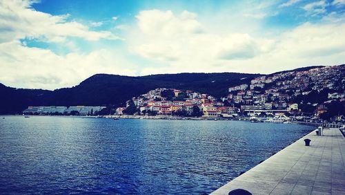 Scenic view of sea by town against sky