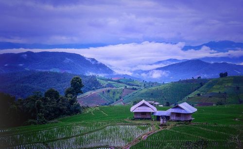 Scenic view of field and mountains against sky