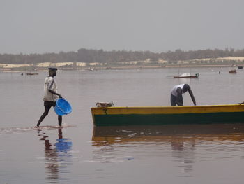 Man surfing on river against sky