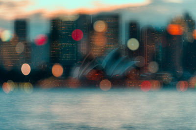 Digital composite image of illuminated city seen through glass window