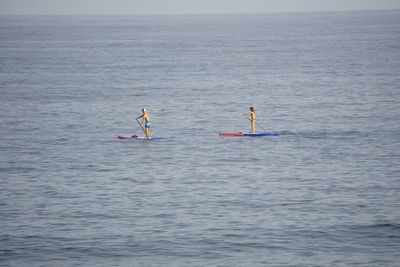 People on sea against sky