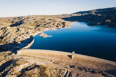 High angle view of dam by lake against clear sky