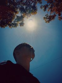 Low angle view of woman looking away against sky