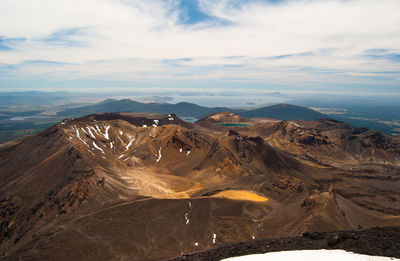 High angle view of volcanic landscape against cloudy sky