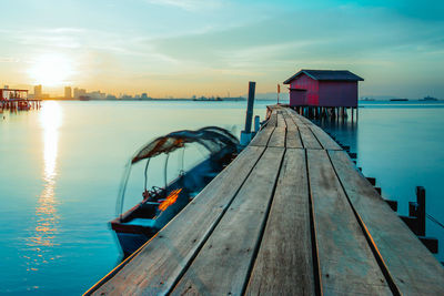 Pier over sea against sky during sunset