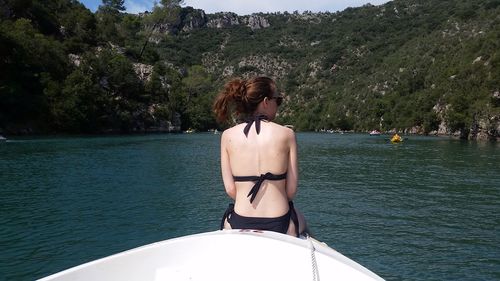 Rear view of woman in bikini by sea