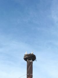 Low angle view of communications tower against sky