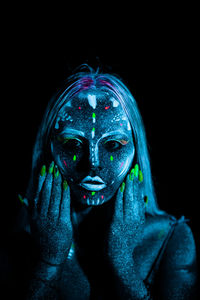 Portrait of a woman wearing mask against black background