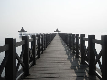 View of pier on sea against clear sky