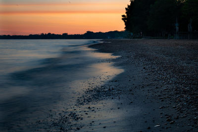 Scenic view of beach against sky during sunset