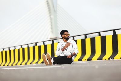 Young man sitting on railing