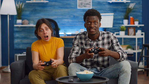 Portrait of couple playing video games at home